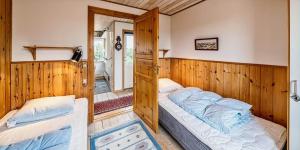 two beds in a room with wooden walls at VE361-Vejers-Strand-Violvej-4 in Vejers Strand