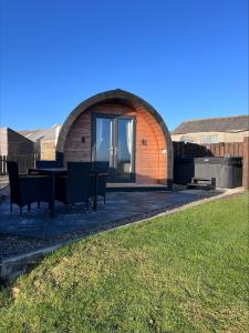 a circular building with a table and chairs in a yard at Millfield Glamping Pods - Heatherhouse in Orkney +9 photos