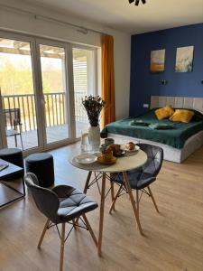 a room with a table and chairs and a bed at Flauta Apartamenty in Augustów