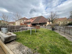 ein Hof mit Zaun und ein Haus in der Unterkunft HostHelp - Les Balises in Bevaix