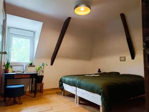 a bedroom with a bed and a desk and a window at Les champs sauvages in Saint-Barnabé