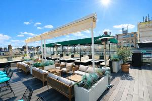 a patio with couches and tables on a roof at Courthouse Hotel London in London