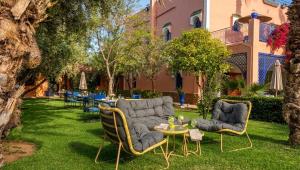 a garden with two chairs and a table and a couch at RIAD REDWAN in Marrakesh