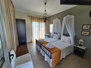 a bedroom with a bed with mosquito nets on it at Villa Niki in Serifos Chora