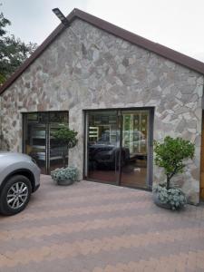 a car parked in front of a stone building at Stadion Sleepover Cabin in Sasolburg