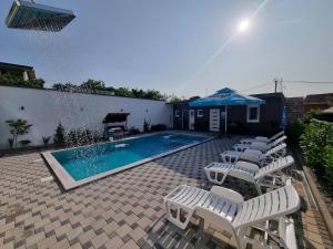 a swimming pool with chairs and a piano next to a house at Holiday Home with Private Pool in Blagaj
