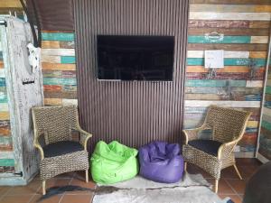 two chairs with colorful bags sitting next to a wall at Stadion Sleepover Cabin in Sasolburg