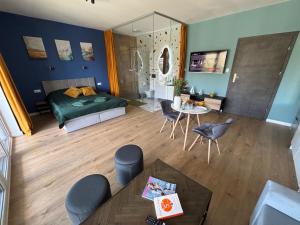 a room with a bed and a table and chairs at Flauta Apartamenty in Augustów