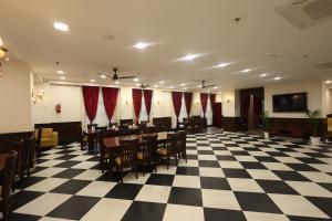 a restaurant with tables and chairs on a checkered floor at Hotel Shringar Mahal Vrindavan in Chhatikara