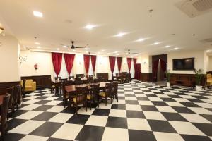 a conference room with tables and chairs on a checkered floor at Hotel Shringar Mahal Vrindavan in Chhatikara