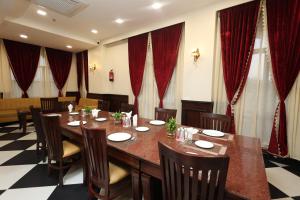 a conference room with a large wooden table and chairs at Hotel Shringar Mahal Vrindavan in Chhatikara