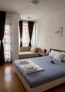 a bedroom with a bed and a couch at Apartmani Marija in Ohrid