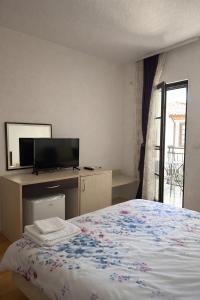 a bedroom with a bed and a flat screen tv at Apartmani Marija in Ohrid