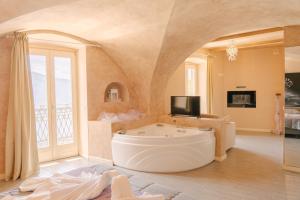 a large bathroom with a tub and a tv at Hotel Miralago in Tremosine Sul Garda