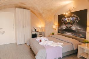 a bedroom with two beds with a painting on the wall at Hotel Miralago in Tremosine Sul Garda +68 photos