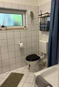 a bathroom with a black toilet and a window at Apartment am Bahnhof mit Self-Check-in in Coburg +2 photos