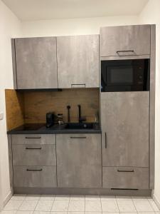 a stainless steel kitchen with a sink and a microwave at Apartment am Bahnhof mit Self-Check-in in Coburg