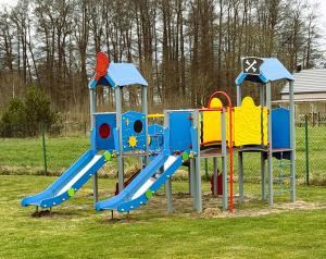 a playground with a slide in a park at Pokoje Gościnne Kameralnie in Jantar