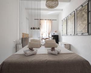 a white bedroom with a large bed with two pillows at Home de mar in Alghero
