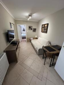 a living room with a bed and a table and a television at Nice apartment close to the sea in Athens