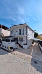 a large white house with a balcony and a driveway at PRETTY HOUSE in Pamukkale