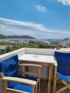 a table and chairs on a balcony with a view of the ocean at Villa Niki in Serifos Chora