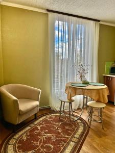 a living room with a table and a chair and a window at Гостьовий Дім Guest House in Kotowsk