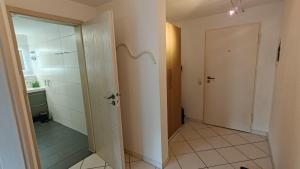a bathroom with a toilet and a door with a mirror at Ferienwohnung Waldblick in Allensbach +7 photos