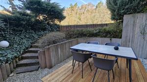 a table and chairs in a garden with a fence at Ferienwohnung Waldblick in Allensbach