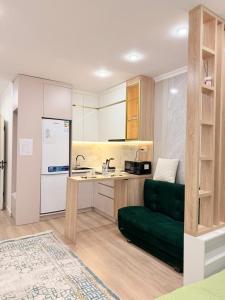 a kitchen with a green couch in a room at Ulytau in Almaty