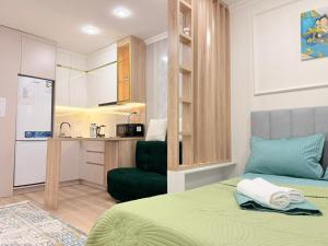 a small room with a bed and a kitchen at Ulytau in Almaty +15 photos