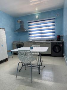 a kitchen with a table and chairs in a room at Résidence central 1 in Nabeul