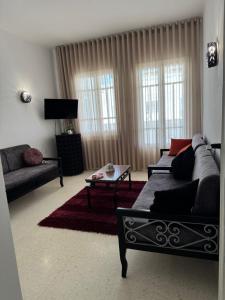 a living room with a couch and a table at Résidence central 1 in Nabeul
