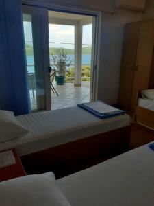 two beds in a room with a view of the ocean at Apartmani ROKO in Neum