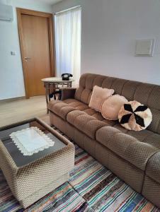 a living room with a brown couch and a table at Cominhos & Quartilhos in Sortelha +25 photos