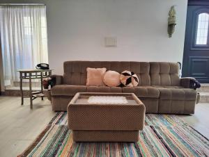 a living room with a brown couch and a table at Cominhos & Quartilhos in Sortelha