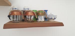 a shelf with cups and vases on it at Atlantis Place Milos in Adamantas