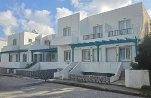 a white building with blue accents on it at Atlantis Place Milos in Adamantas