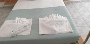 two towels are sitting on a table with a bed at Atlantis Place Milos in Adamantas +33 photos