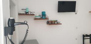 a room with a phone and a tv on a wall at Atlantis Place Milos in Adamantas
