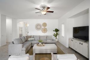 a living room with a couch and a ceiling fan at Gorgeous Lakefront Paradise w Pool & Views in Chandler
