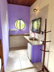 a purple bathroom with a sink and a window at Loft com vista Panoramica in Paraty +15 photos