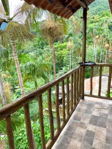 a wooden balcony with a view of the jungle at Loft com vista Panoramica in Paraty