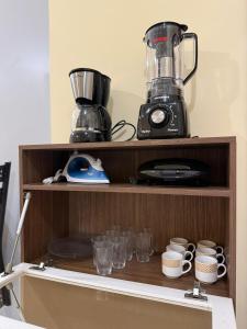 a shelf with a blender and cups on it at Centro de Alfenas Térreo Completo in Alfenas