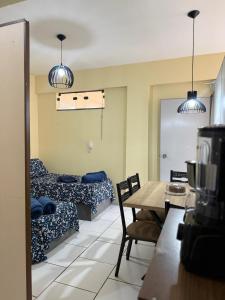a living room with two beds and a table at Centro de Alfenas Térreo Completo in Alfenas