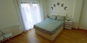 a bedroom with a bed and two windows at EnFOZ Terraza XXL Pet Friendly in Foz