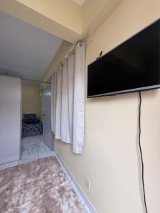 a living room with a flat screen tv on a wall at Centro de Alfenas Térreo Completo in Alfenas +11 photos