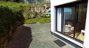 a patio with a window and a chair in a house at EnFOZ Terraza XXL Pet Friendly in Foz