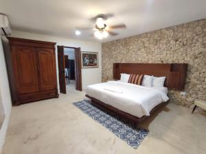 a bedroom with a bed and a stone wall at Boutique Casa Azuli Santiago in Mérida