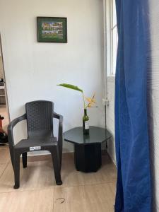 a chair and a table in a room with a chair and a plant at ECOHostal Las Hamacas el colibrí in Villamaría +1 photo